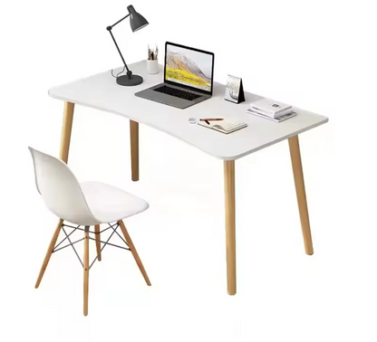A simple design computer desk with a black rectangular MDF top and wooden legs, displayed in a home setting with a laptop, books, and a plant on it.
