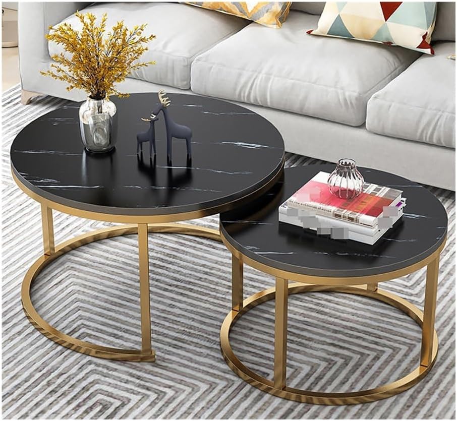 Set of two round coffee tables with black marble tops and gold metal bases in a living room setting.