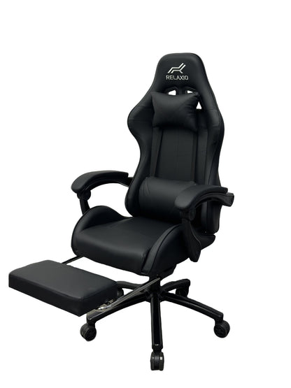 Black and white gaming chair with headrest and footrest, featuring an ergonomic design with a gas lift, cushion, and a steel backrest.